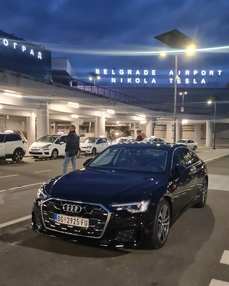 Black Audi A6 of Passenger Transfers outside Belgrade Nikola Tesla Airport at night
